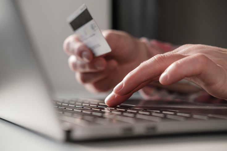 a person typing their bank details into a computer