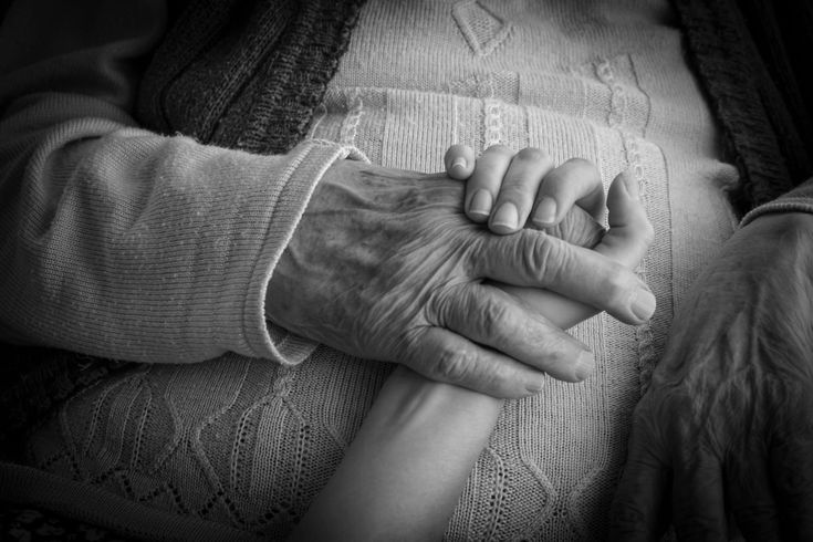 an old person holding hands with a young person